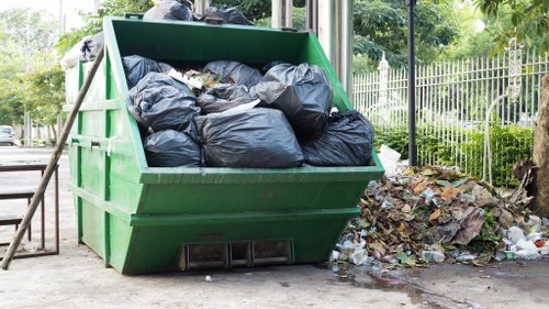 Worker loading garden waste into a van for disposal in Islington